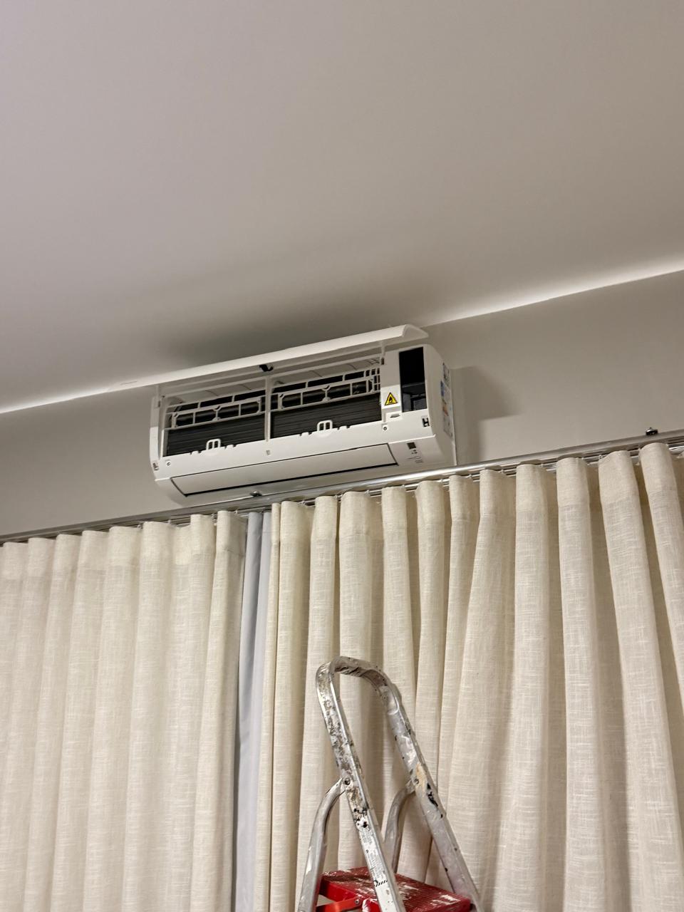 Split hi-wall instalado em sala com acabamento alinhado à cortina
